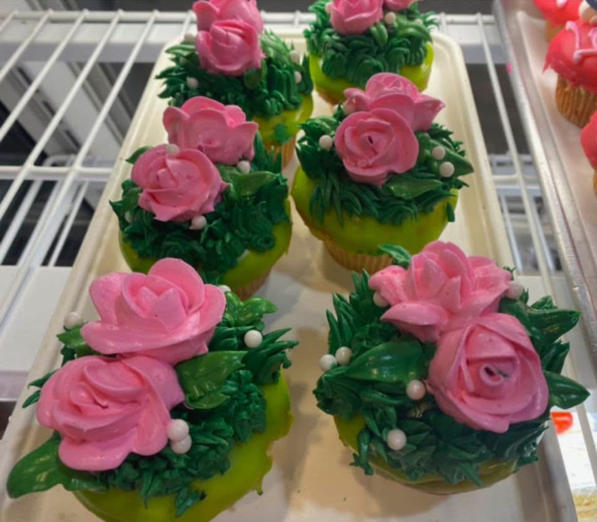 Rose-topped mini cakes in green icing