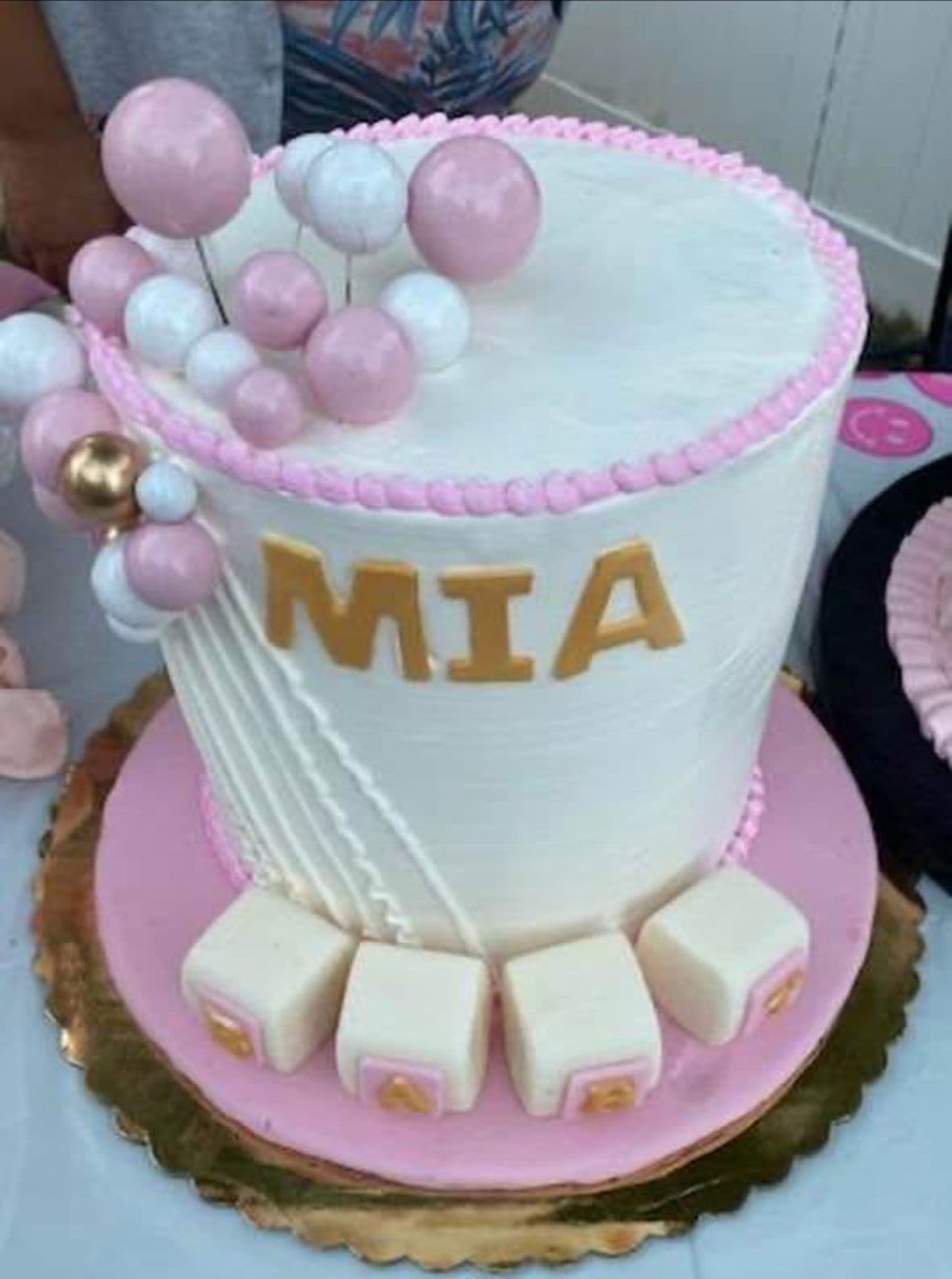 Pink and white celebration cake with balloons