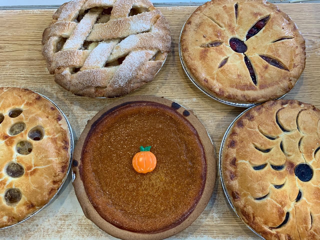 Assorted lattice-topped fruit and pumpkin pies